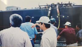 Fotografía de visita a Rambala, Panamá. Aparecen 6 hombres mirando hacia un barco de exportación