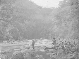 Fotografía de un río de Costa Rica. Se observan grandes piedras y la vegetación del lugar. Se obs...