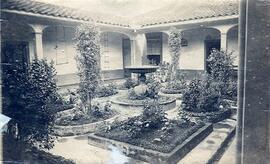 Fotografía del jardín interior de una casa antigua de San José, con su fuente y arreglos de flore...