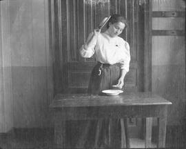 Negativo sobre la vida cotidiana en un lugar no identificado. Se observa una mujer, una mesa pequ...