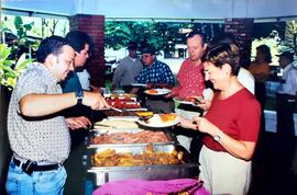 Fotografía de un grupo de diez personas en el rancho de La Rita comiendo