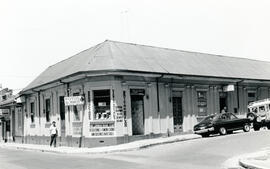 Fotografía de un edificio ocupado por distintos locales comerciales, ubicado al costado oeste del...