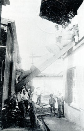 Fotografía de hombres cargando sacos de café en los carros del ferrocarril, hacienda de Julio Sán...