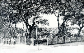 Fotografía del Parque Central en 1909. Se observan algunas personas en la acera y un poste que so...