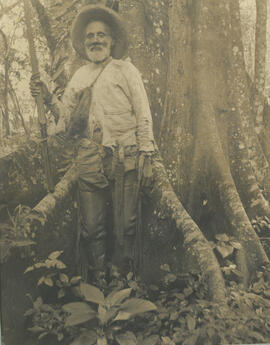 Fotografía de Ñor German sic, conocido como Mata tigres, posando junto al tronco de un árbol, con...