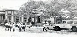 Fotografía del edificio de la Escuela Julia Fernández Cortés. Se observa un grupo de niños escola...