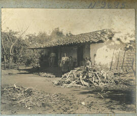 Fotografías en albun de viviendas y familias de un lugar no identificado. Las casas son de adobe ...