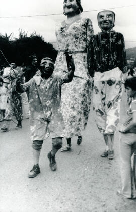 Fotografía con la imagen de desfiles de payasos y público durante los festejos populares de Aserr...