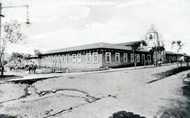 Fotografía del edificio del Hospicio de Huérfanos, se observa parte deteriorada de una calle, alg...