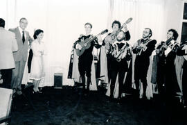 Fotografía de una rondalla realizando una presentación musicial en presencia de Marina Volio Bren...