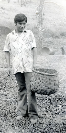 Fotografía de un joven indígena bribrí, sosteniendo un canasto, Talamanca. Limón