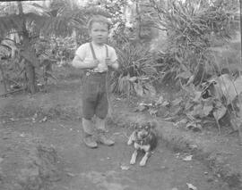 Negativo del niño Joaquín Gil Tristán, posando con un perro. Costa Rica