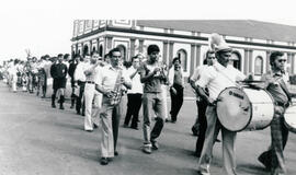 Fotografía con la imagen del desfile de la Banda Municipal y jugadores de balompie por una calle ...