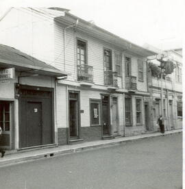 Fotografía de un viejo edificio de madera donde se encuentran las casas número 126-128 y 136, sit...