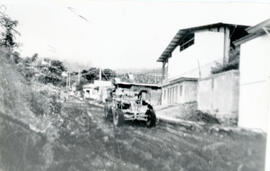 Fotografía panorámica de Escazú. Se observa una motoniveladora reparando un camino vecinal, así c...