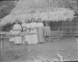 Negativo de un grupo de mujeres y niños frente a un rancho de paja, en Golfito de Puntarenas. Reg...