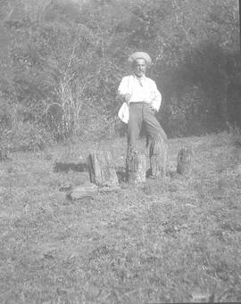 Negativos de Paul Biolley en un terreno poblado de vegetación. Se observan troncos de árboles cor...