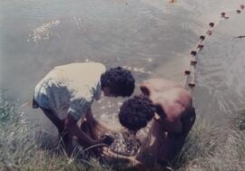 Fotografía de dos hombres atrapando langostinos en un estanque, pertecientes a proyectos de ASBAN...
