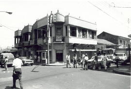 Fotografía de un edificio antiguo, ahí funcionan varias casas comerciales. Parada de Tibás. Calle...